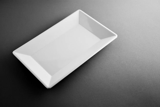 White plastic square dish on black desk