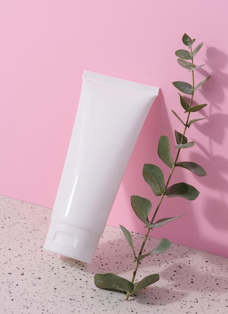 White plastic tube for liquid cosmetics on a pink background packaging