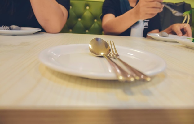 White plate and gold cutlery placed on the table