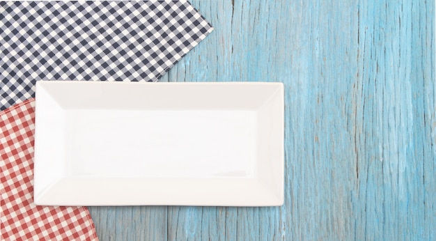 Photo white plate on tablecloth on wood table background