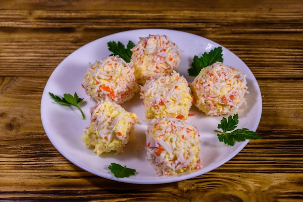 White plate with crab-cheese balls on rustic wooden table