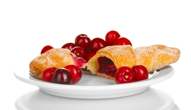 White plate with croissant and cherry isolated on white