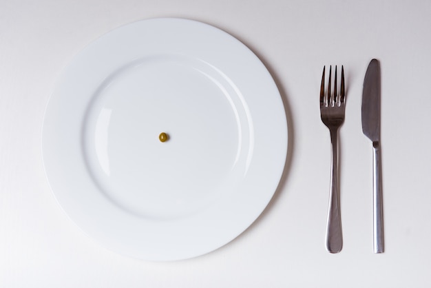 White plate with fork and knife, top view