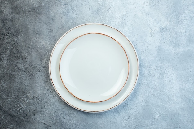 White plates on half dark light gray surface with distressed coarse-grained gradient surface