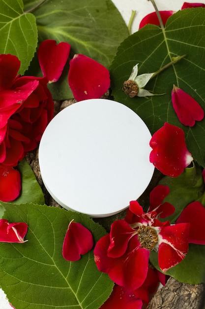 White podium for beauty cosmetics on background of forest leaves moss flowers and petals