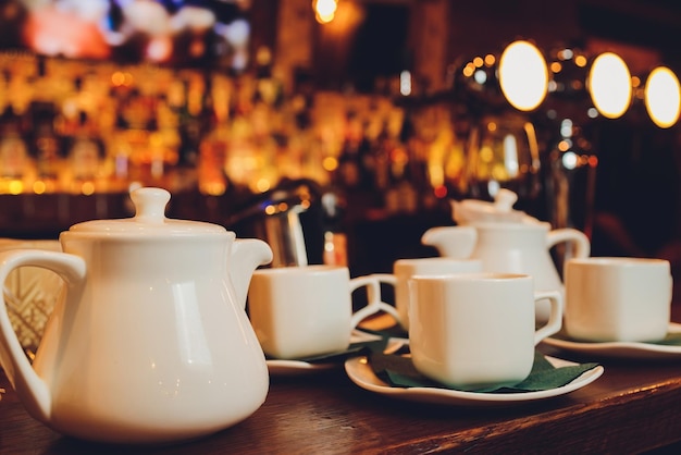 White porcelain tea setfolded cups and saucers and teapot Tea ceremony tableware on a dark background