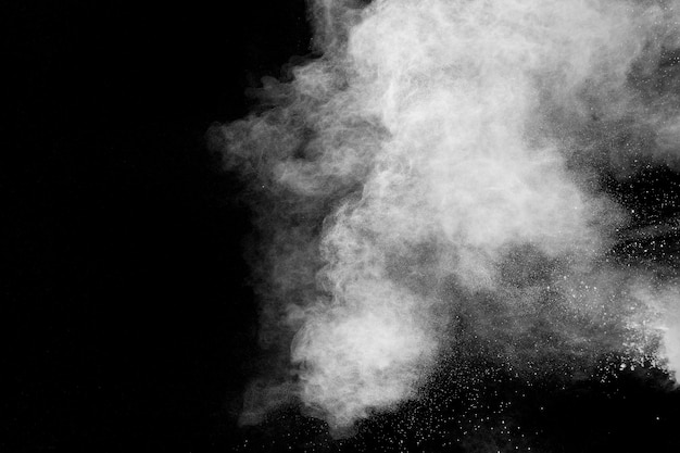 White powder explosion cloud against black background.White dust particles splash.