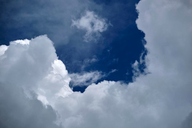 White puffy cumulus clouds on summer blue sky