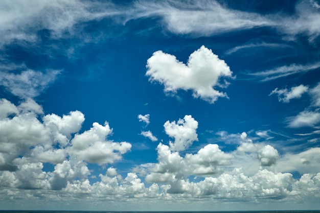 White puffy cumulus clouds on summer blue sky