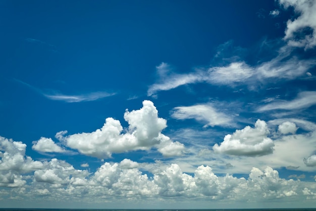 White puffy cumulus clouds on summer blue sky