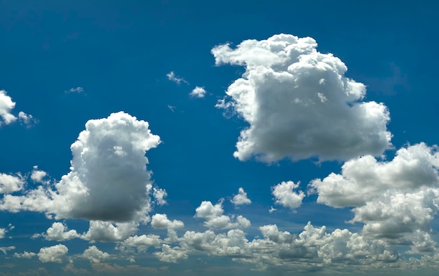 White puffy cumulus clouds on summer blue sky