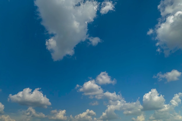 White puffy cumulus clouds on summer blue sky