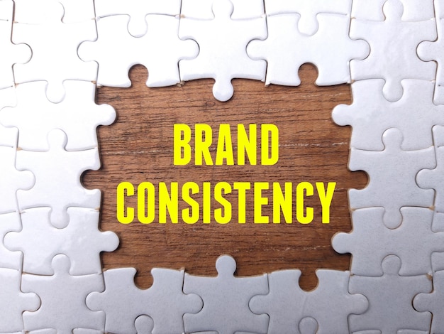 White puzzle with the word BRAND CONSISTENCY Business concept