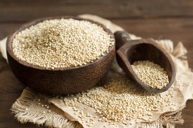 White Quinoa in a bowl with a wooden spoon close up