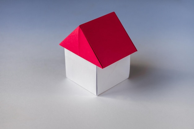 White and red paper house origami isolated on blank background