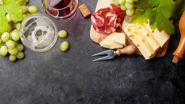 White and red wine glasses grape and appetizer board