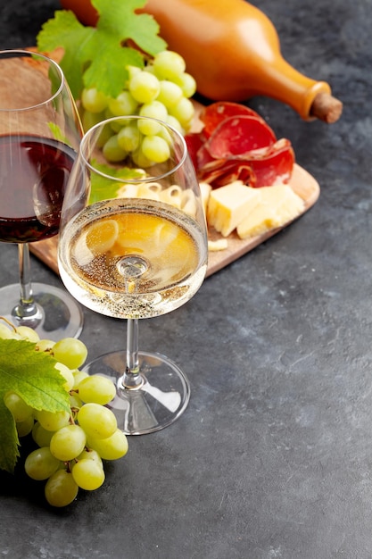 White and red wine glasses grape and appetizer board