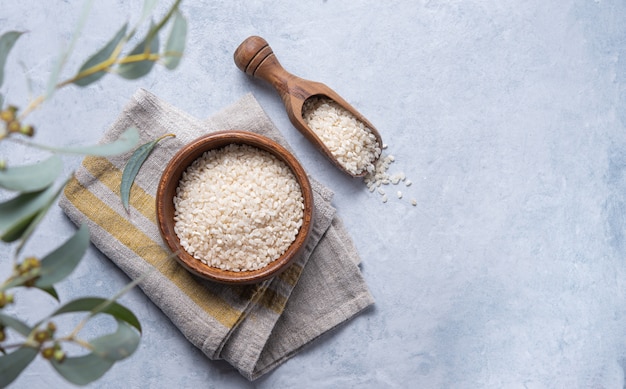 White rice Arborio in a wooden bowl on a napkin