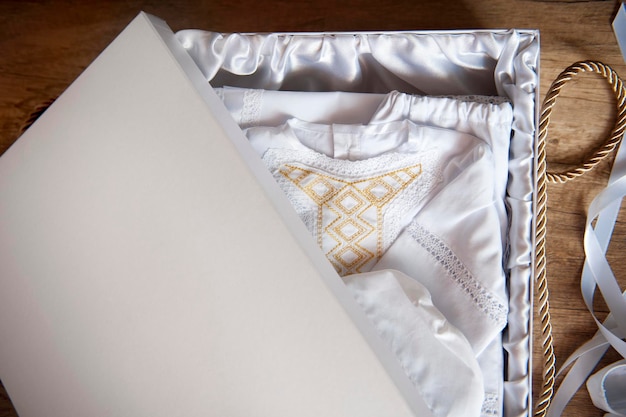 White robe embroidered with gold in a box