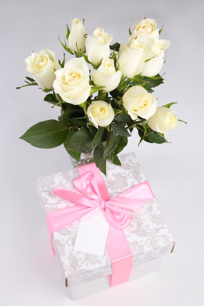 White roses and gift box with blank card for text