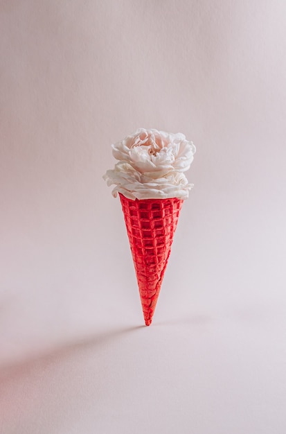 White roses in a red waffle cone on beige background selective focus with copy space