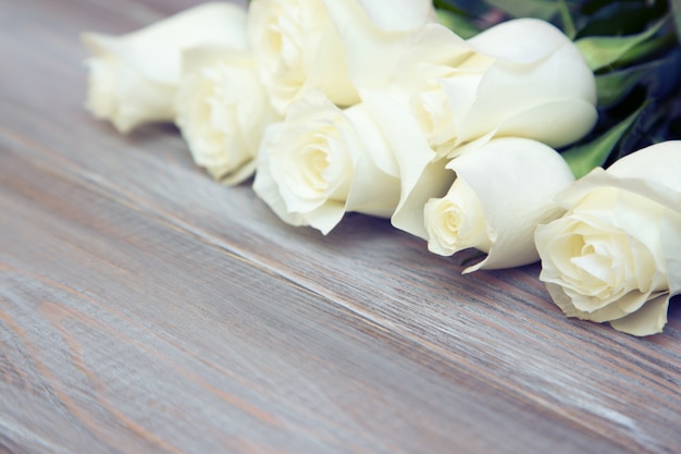 White roses on a wood background