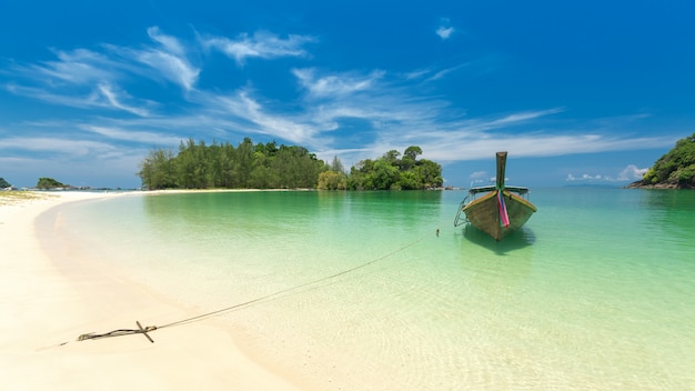 Photo white sand beach and long-tail boat at kham-tok island (koh-kam-tok), thailand.