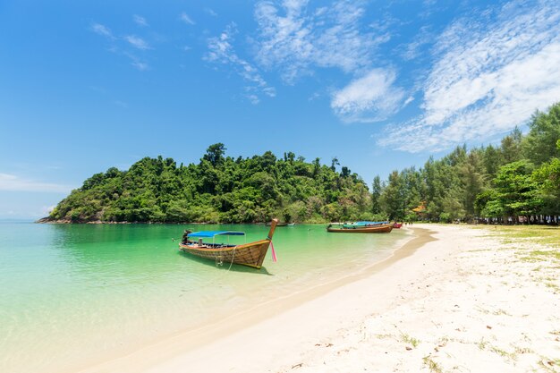 Photo white sand beach and long-tail boat at kham-tok island (koh-kam-tok)