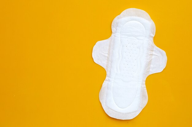 White sanitary napkin on yellow surface