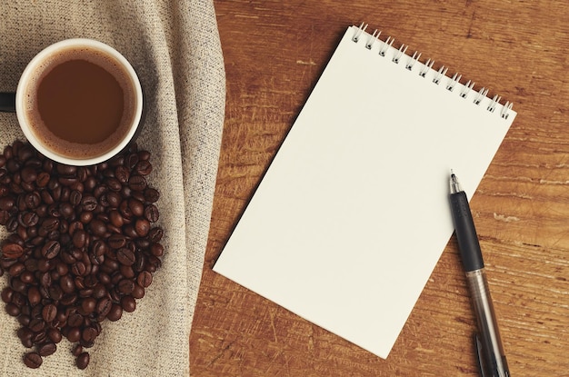 White sheet for writing and coffee on wooden table