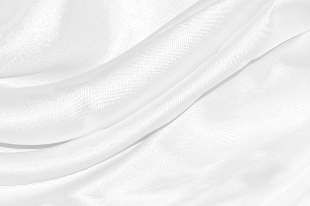 White silk textured cloth backgroundCloseup of rippled satin fabric with soft waves