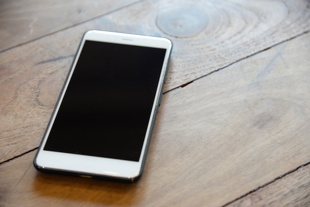 White Smart phone in black case on the wood table prepared for management teams to contact with customer in business