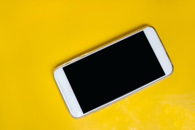 White smart phone on yellow table