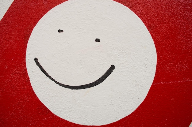 Photo white smiley face on red background