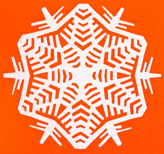 White snowflake on orange paper