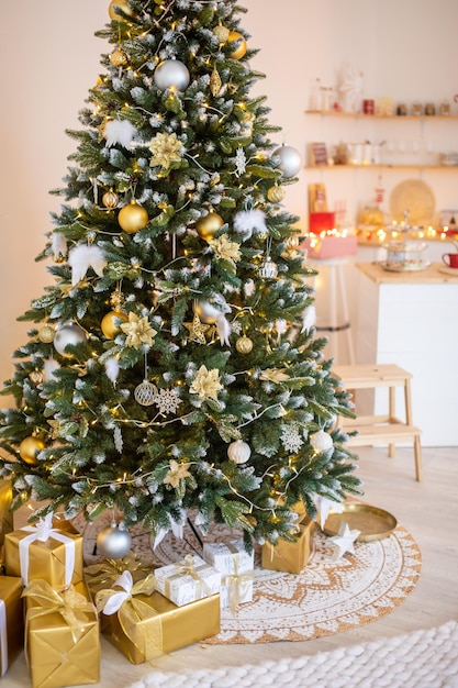 White snowy christmas tree with gifts decor interior of the house new year