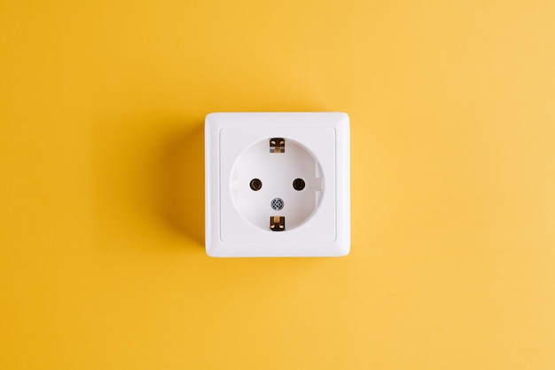 Photo white socket isolated on yellow background electric lighting concept