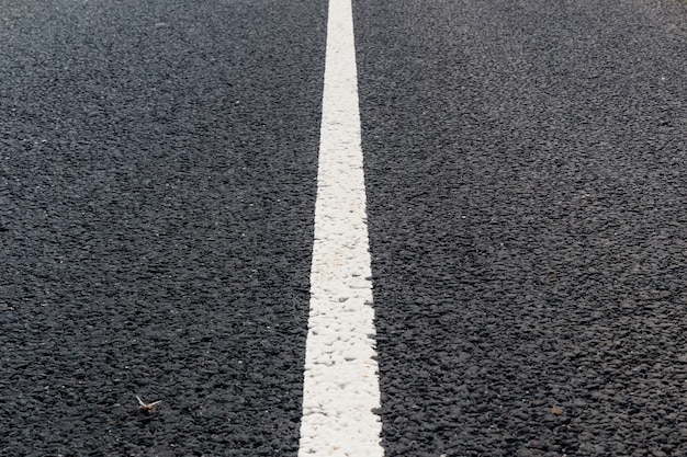 White solid line. Road marking on an asphalt road.