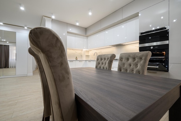 White spacious kitchen interior with dining room table and chairs