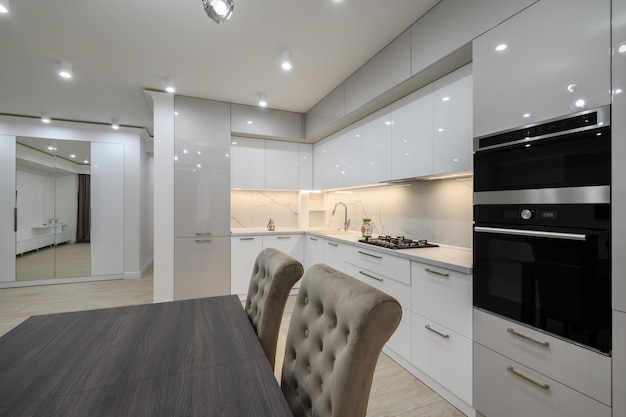 White spacious kitchen interior with dining room table and chairs