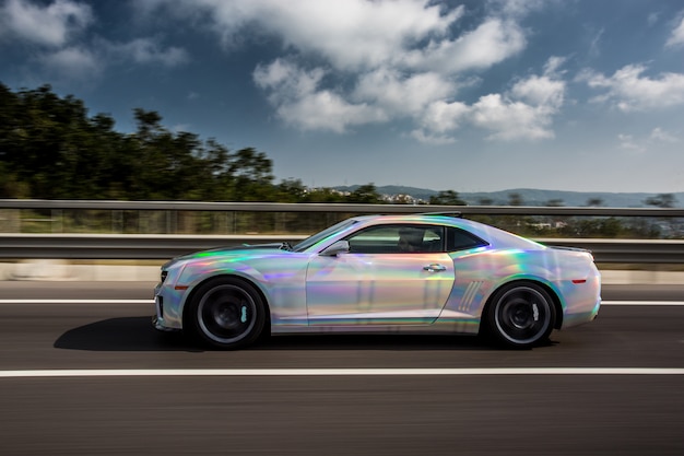 White sport car with blue autotuning on the road