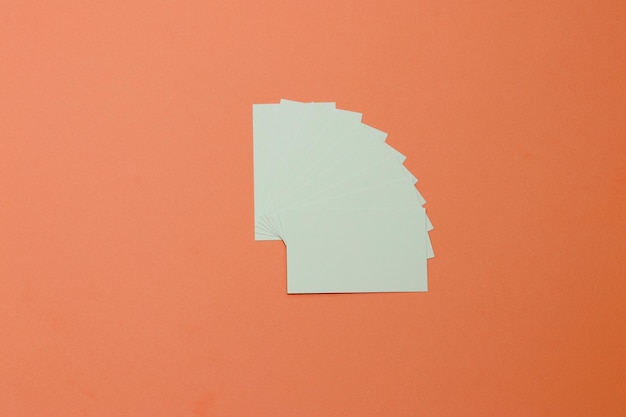 Photo a white square piece of paper on an orange background