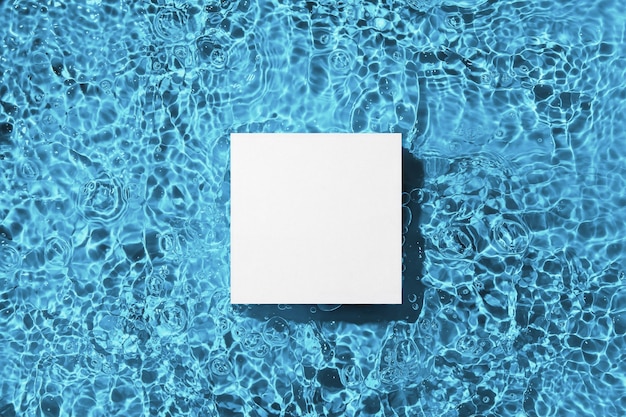 White square podium on the blue water surface background Flat lay copy space