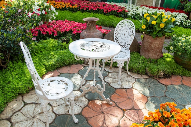 White steel table and chairs in beautiful flower garden