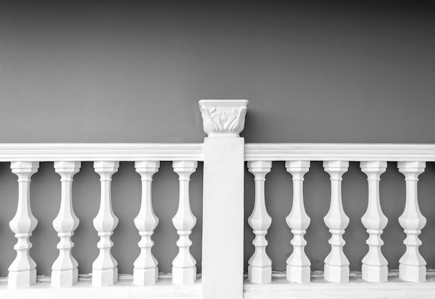 White stone column fence balustrade opposite grey cement wall