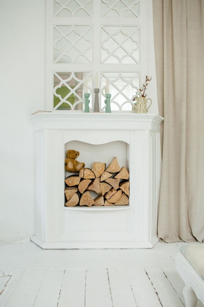 White stone fireplace with firewood without fire