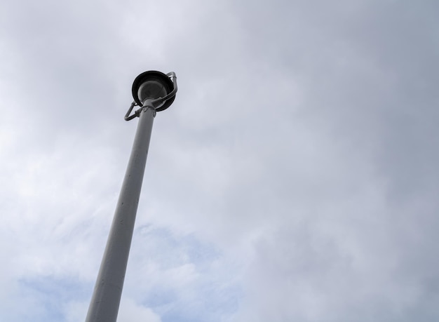 white streetlight from below over cloudy sky