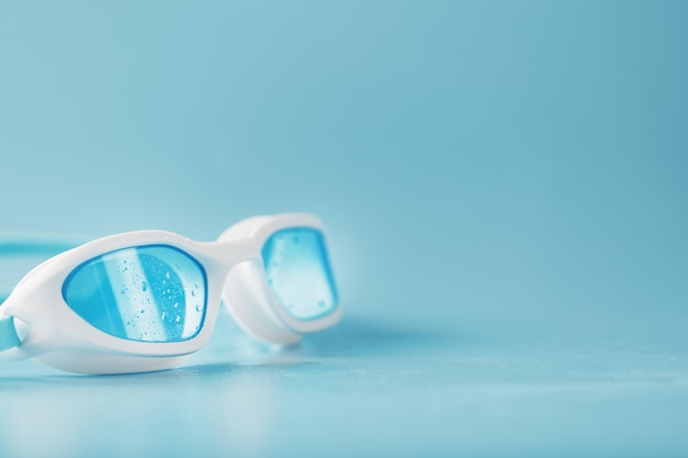 White swimming glasses with a blue lens