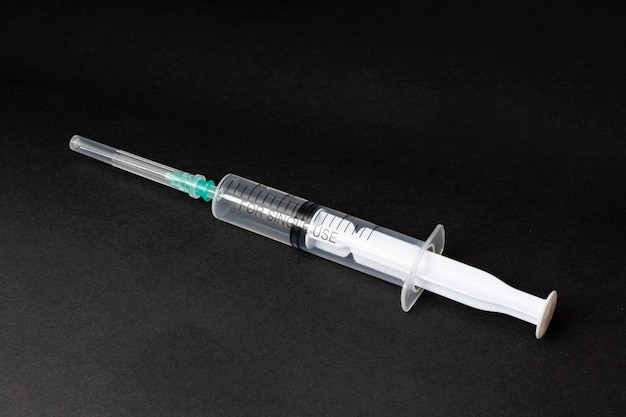 White syringe on a black background closeup