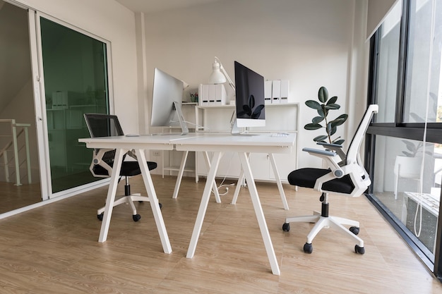 White table and chair with computer monitor and modern file cabinet in white home office